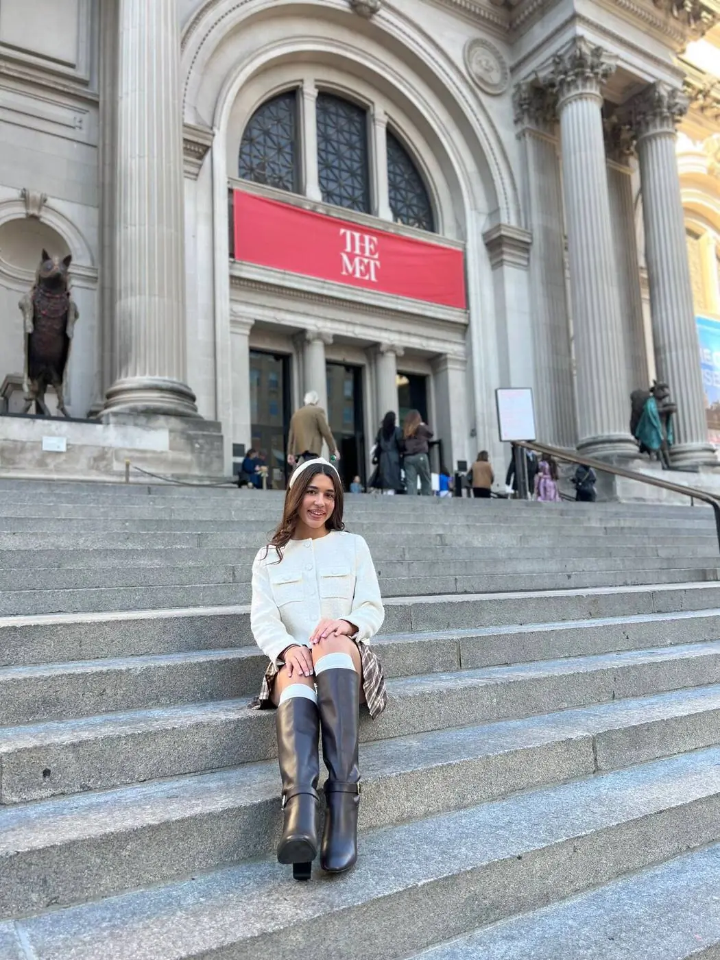 Guest in a white jacket and headband on the Met Steps in winter, Blair Waldorf style