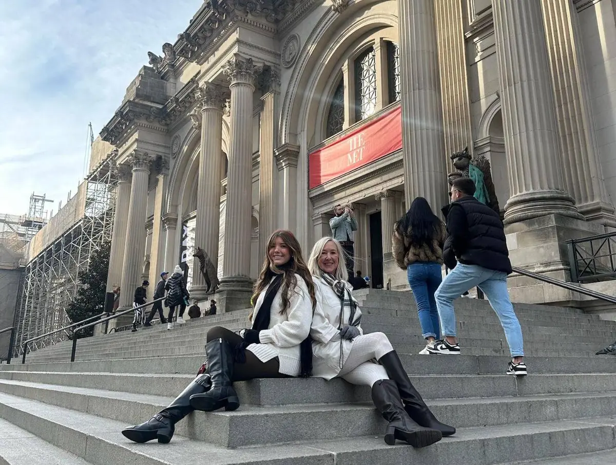Mother and daughter sitting on the Met Steps on a winter Gossip Girl Tours visit